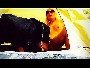 Curvy unmasked blonde is fucking with a dog by the tent